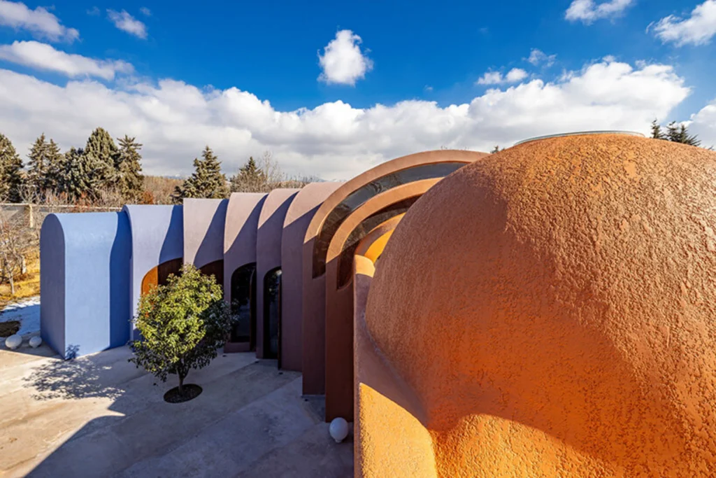 Close-up of overlapping earth-toned and blue vaulted roofs at Gelareh House