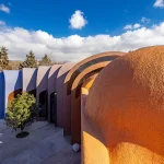 Close-up of overlapping earth-toned and blue vaulted roofs at Gelareh House