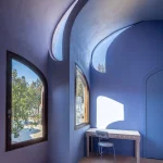 Interior blue vaulted room with arched openings and a simple white table
