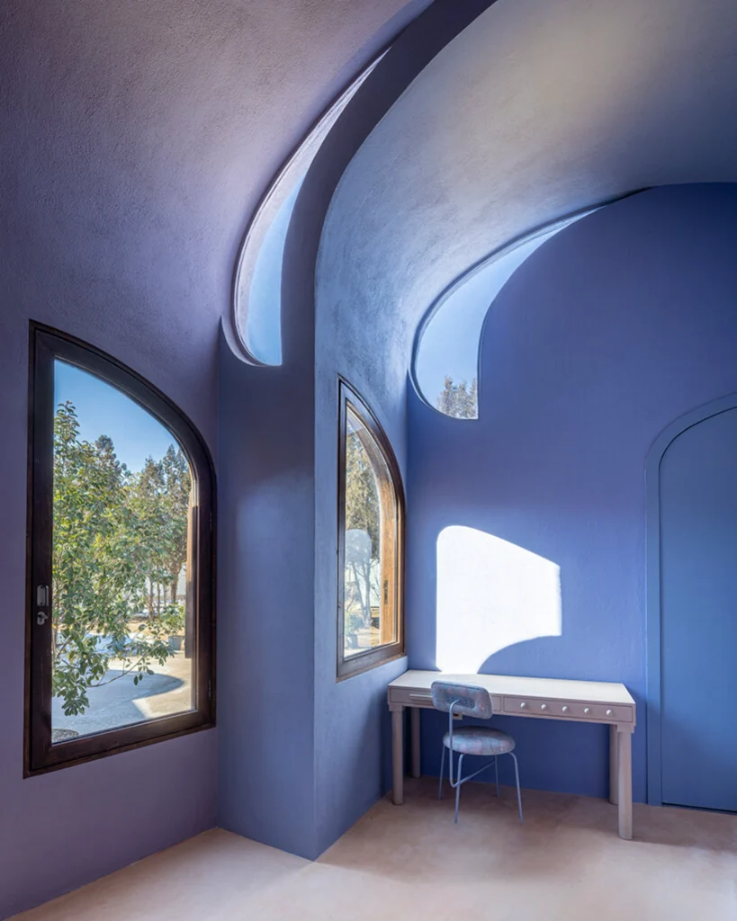 Interior blue vaulted room with arched openings and a simple white table