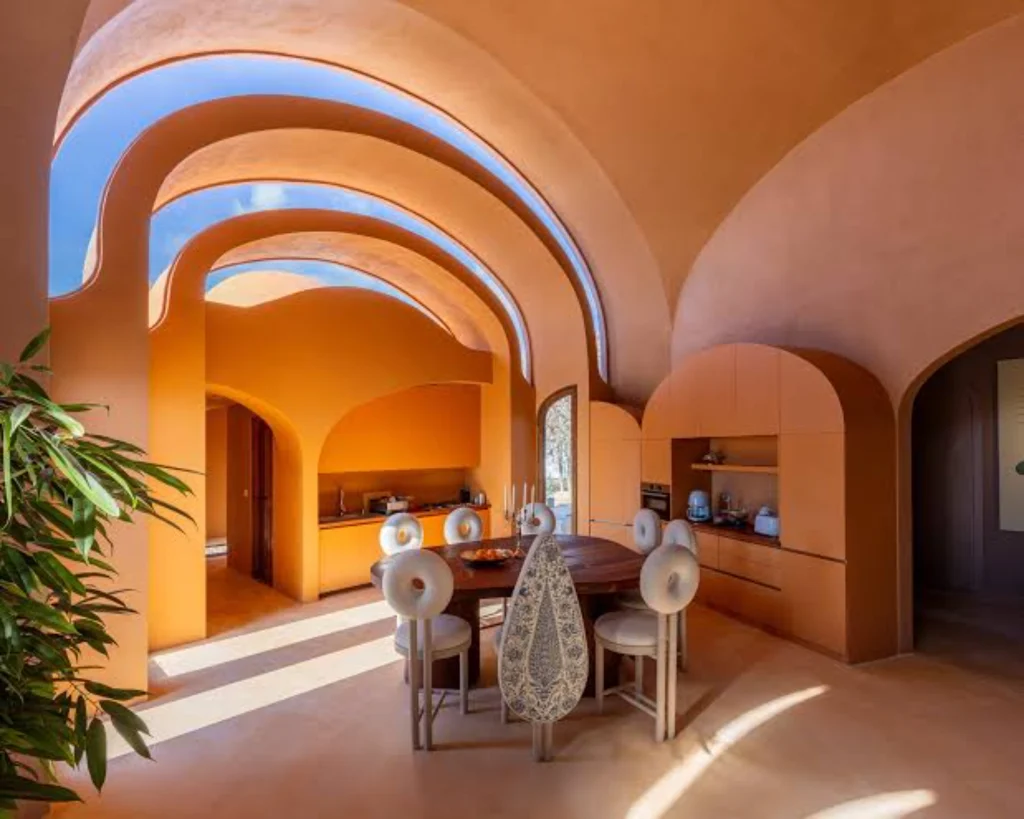 Warm-toned vaulted interior with arched doorways and dining area at Gelareh House