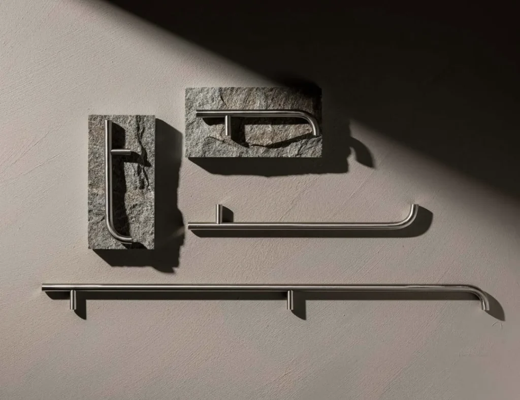 Close-up of custom cabinet handles combining brushed stainless steel and natural stone, highlighting geometric forms, material textures, and modern hardware design for interior renovation projects