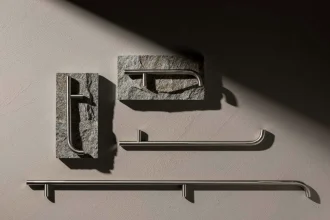 Close-up of custom cabinet handles combining brushed stainless steel and natural stone, highlighting geometric forms, material textures, and modern hardware design