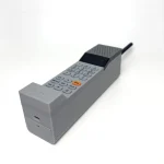 Side view of the grey 3D-printed ADHD ONE handset showing the keypad, orange Send button and charging port