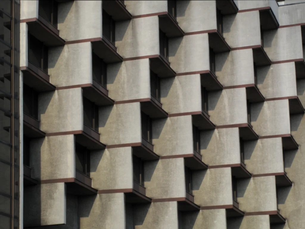 Tight close-up of the repeating concrete balcony modules and deep reveals that create a rhythmic pattern across the façade