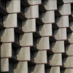 Tight close-up of the repeating concrete balcony modules and deep reveals that create a rhythmic pattern across the façade