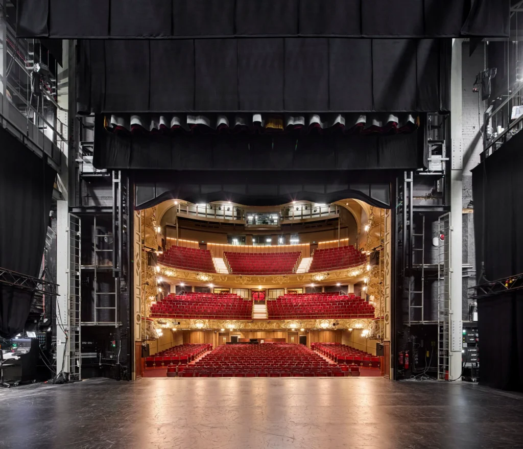 View from the stage looking out into the ornate auditorium with red seating and gold detailing