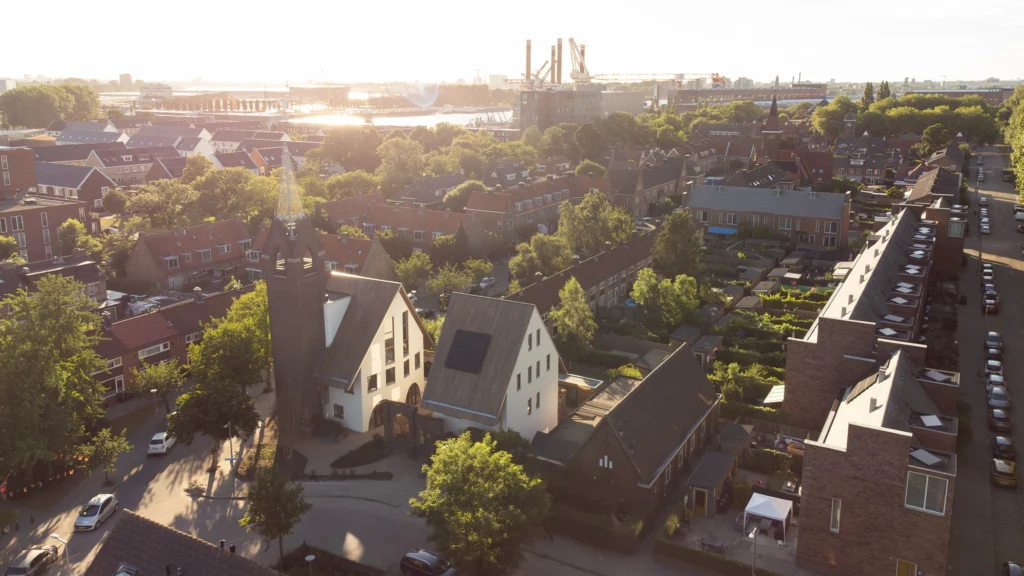 Aerial view of JUUL at sunset showing the tower, new houses and surrounding Heijplaat neighbourhood