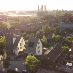 Aerial view of JUUL at sunset showing the tower, new houses and surrounding Heijplaat neighbourhood