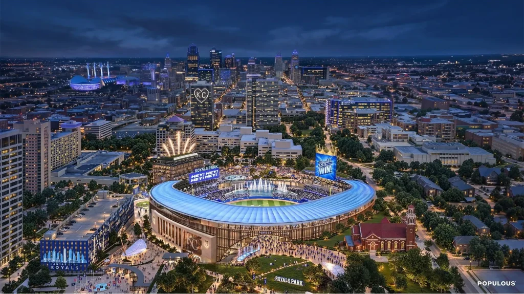 Night aerial rendering of the proposed Royals ballpark glowing blue amid the Kansas City skyline and surrounding district