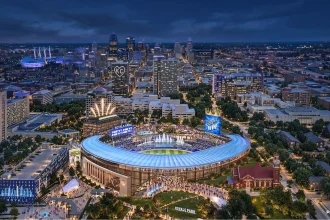 Night aerial rendering of the proposed Royals ballpark glowing blue amid the Kansas City skyline and surrounding district