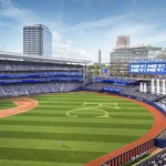 High-angle view of the playing field with outfield fountains, scoreboards and city buildings beyond