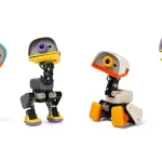 Four Microduck robots in different colours (blue, grey, cream and purple) standing in a row against a white background