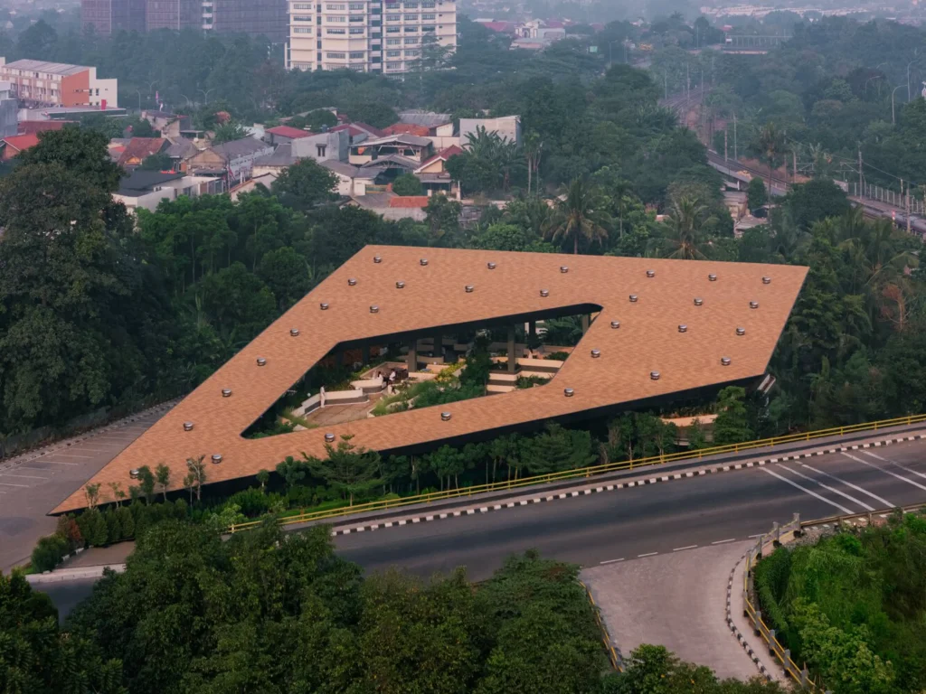 Overhead aerial of the angular, terracotta-tiled roof of Mitte Oblique Garden featuring a large irregular central opening, multiple circular roof vents, and visible landscaped interior spaces below.