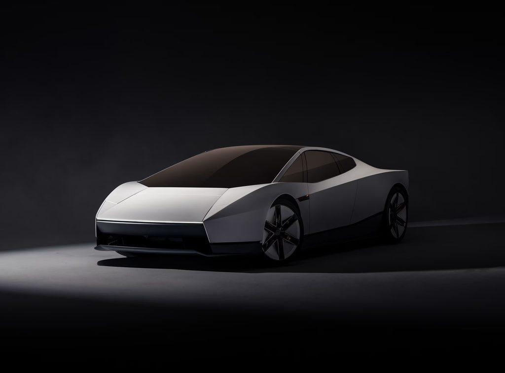 Front three-quarter view of the white Tesla Roadster in a dark studio setting
