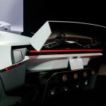 Rear view of the Roadster with active wing deployed under red stage lighting