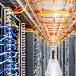 Interior of an AI data center with densely arranged server racks, colorful network cables, and overhead cable management systems for high-performance computing