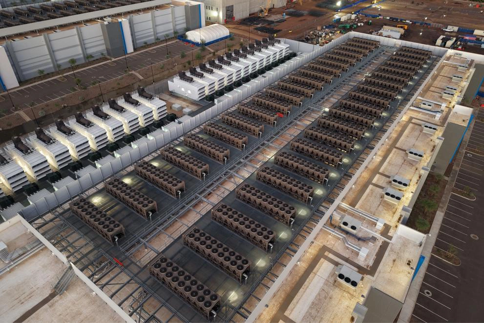 Elevated view of extensive data center cooling infrastructure, showing rows of industrial cooling units, ventilation equipment, and mechanical systems