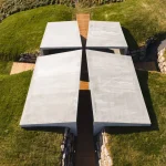 Direct overhead view of the four concrete roof arms forming a cross around the central wooden path and circle