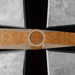 Close overhead detail of the wooden Celtic-cross floor meeting at a circular center under concrete edges