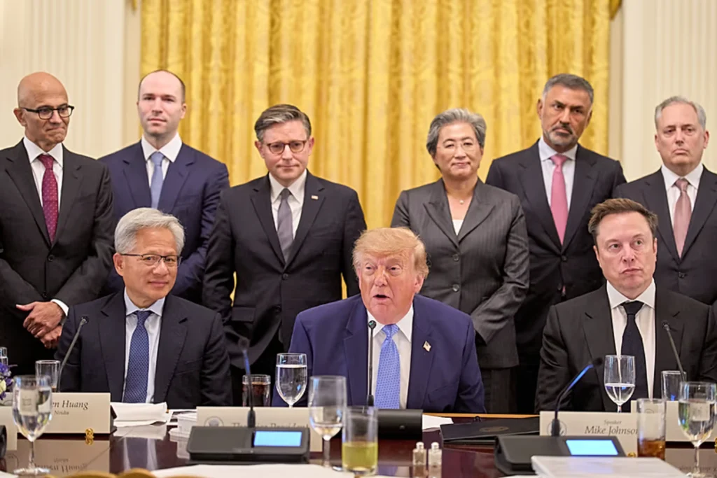 Trump AI Pact: Donald Trump sits at a conference table surrounded by tech executives and government officials, including Jensen Huang, Elon Musk, Satya Nadella, and Mike Johnson