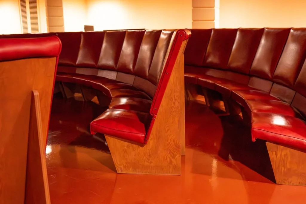Close-up of the original plywood and red vinyl seats restored in their curved arrangement