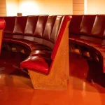 Close-up of the original plywood and red vinyl seats restored in their curved arrangement
