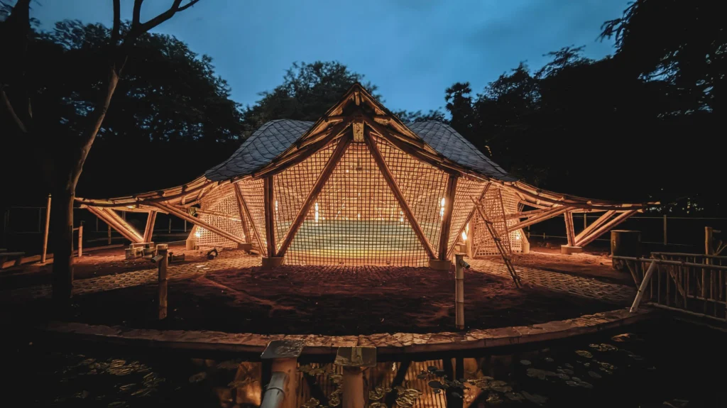 Bamboo Vaults Radically Shape Music Research at IIT Madras Center_Night view of a glowing bamboo pavilion with lattice walls and sweeping roof illuminated from within