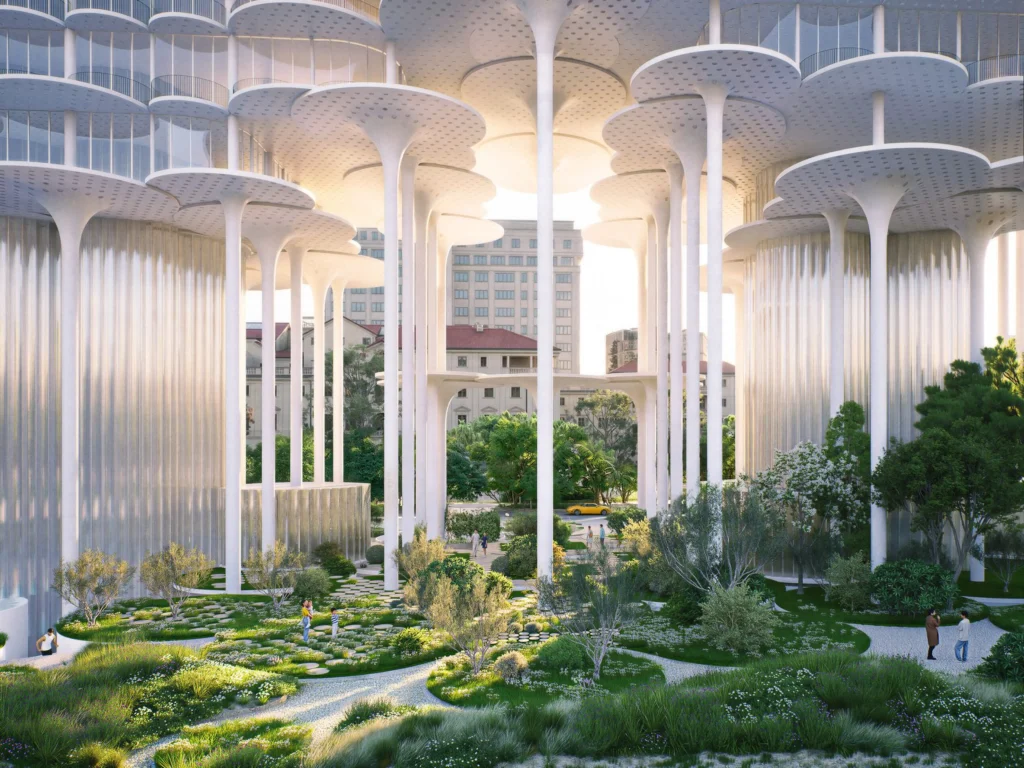 Ground-level view under the building showing tall white columns, hanging water curtains and landscaped public pathways