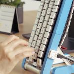 Blue Gboard conveyor-belt keyboard standing upright on a white background, showing white keycaps