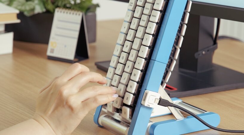 Blue Gboard conveyor-belt keyboard standing upright on a white background, showing white keycaps