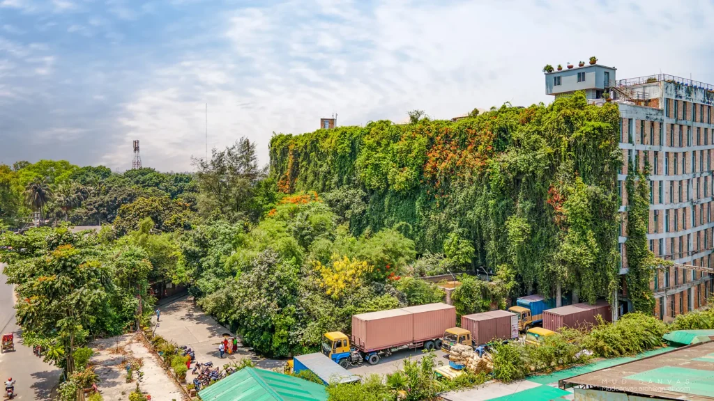 Aerial view of the factory’s living green wall covered in dense vegetation beside a tree-filled compound