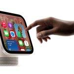 Hand interacting with a HomeView display showing apps, weather and calendar widgets