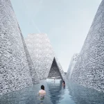 People swimming in an outdoor pool channelled between tall, textured brick walls under a clear blue sky