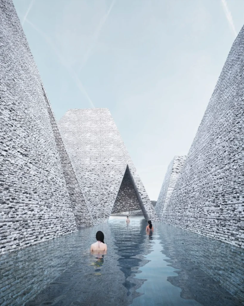 People swimming in an outdoor pool channelled between tall, textured brick walls under a clear blue sky