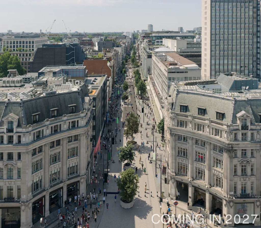 Aerial rendering of the planned Oxford Street pedestrianization in London, showing a traffic-free shopping boulevard with trees, public seating, pedestrians, and wider walking areas, expected in 2027