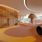 Wide view of the indoor play area with wooden slat structures, soft coloured flooring and climbing elements