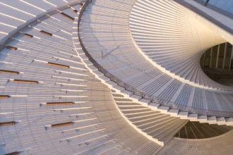 Aerial close-up of the spiraling white roof terrace with wooden benches and a single person walking