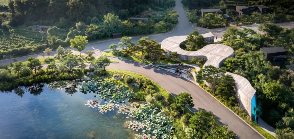 Suseong Continuum by Büro Ole Scheeren, showing its flowing concrete roof and landscaped lakeside setting