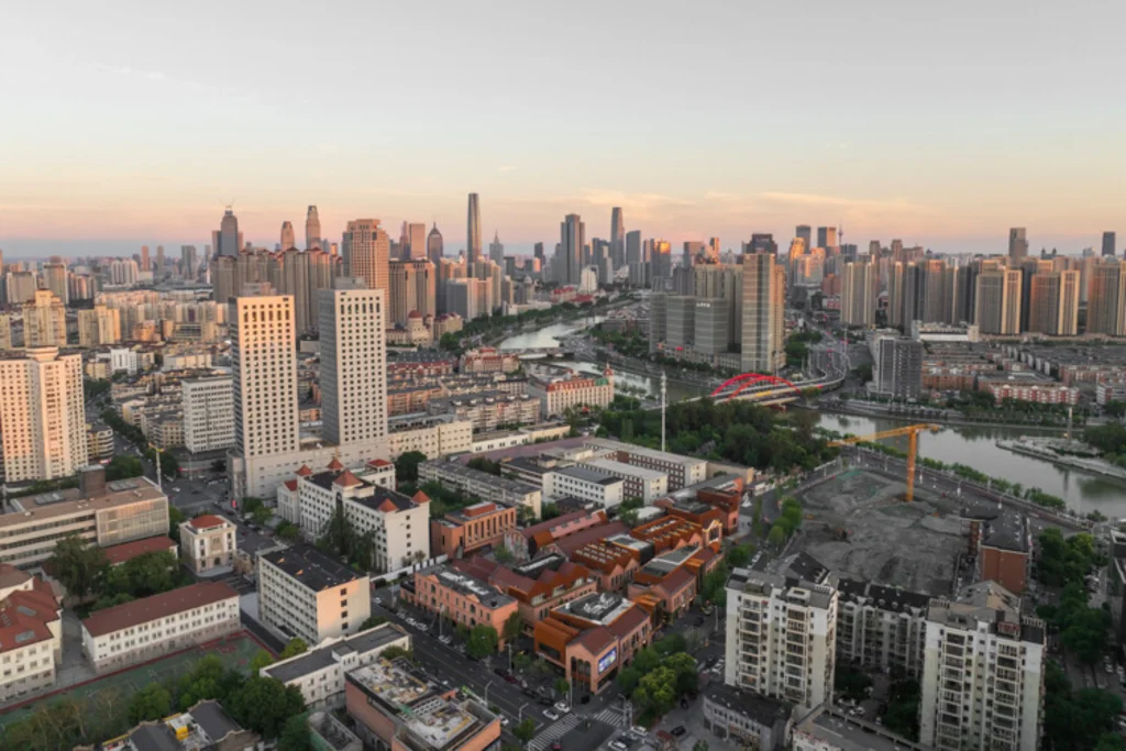 Aerial view of the TAFA Art Block core area within the denser Tianjin cityscape at dusk