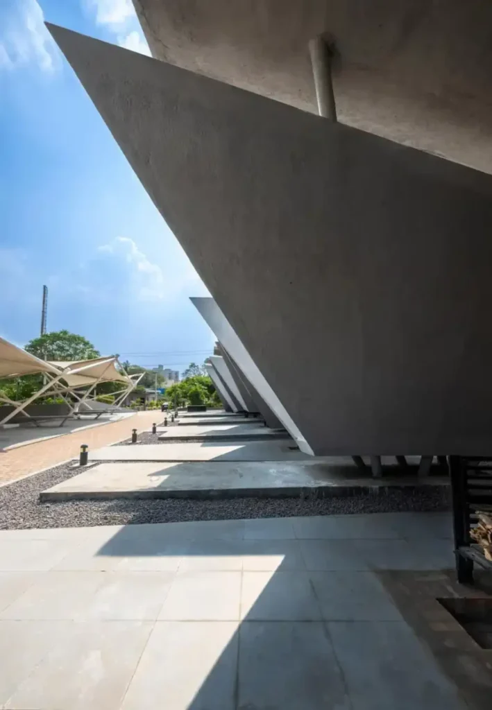 Close-up of sharp concrete edges and deep shadows cast by the overlapping planar forms of the pyres