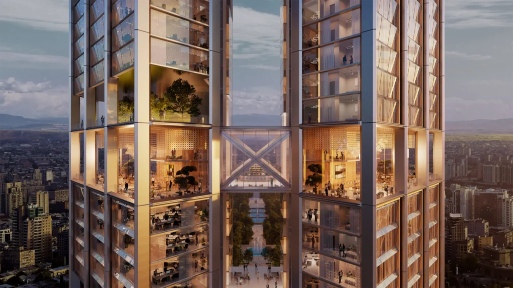 Close-up view of the two glass towers connected by a sky bridge, with illuminated offices and planted terraces visible through the façades at dusk
