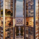Close-up view of the two glass towers connected by a sky bridge, with illuminated offices and planted terraces visible through the façades at dusk