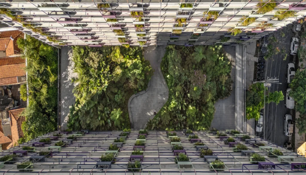 Aerial view of a dense green courtyard with winding paths between two multi-storey residential buildings